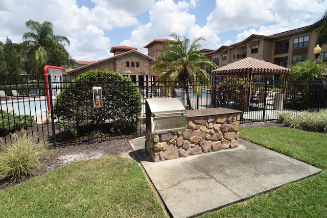 view of community featuring a gazebo, a lawn, and an outdoor kitchen