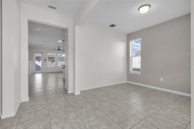 tiled empty room featuring ceiling fan