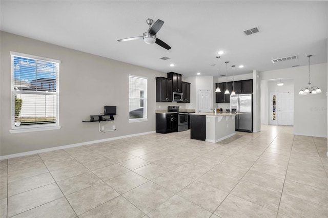 kitchen with ceiling fan, a center island, stainless steel appliances, and decorative light fixtures