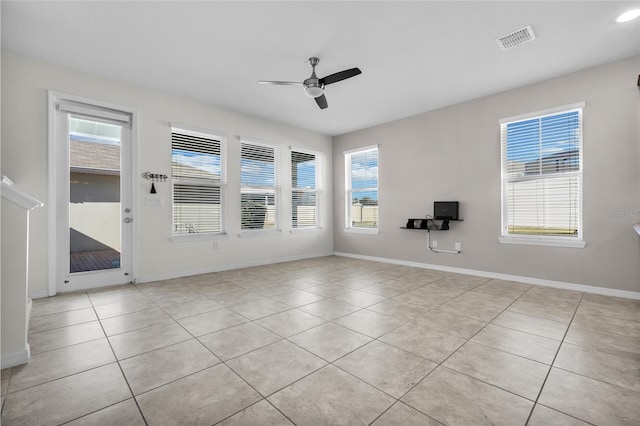 unfurnished room featuring ceiling fan, plenty of natural light, and light tile patterned floors