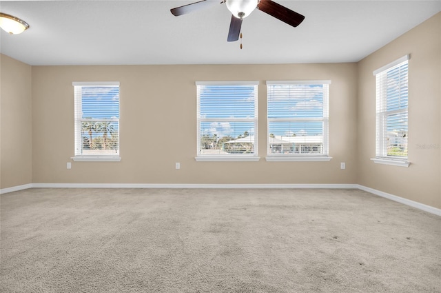 carpeted spare room featuring ceiling fan