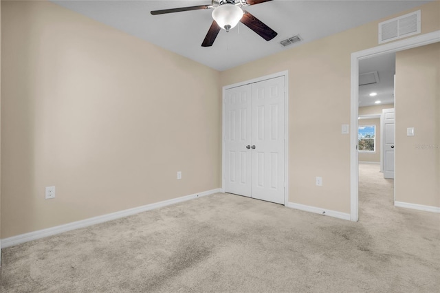 unfurnished bedroom with ceiling fan, a closet, and light carpet