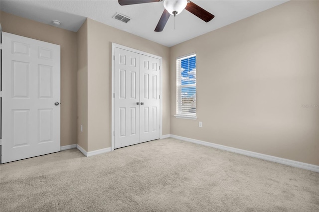 unfurnished bedroom featuring ceiling fan, light colored carpet, and a closet