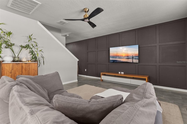 living room featuring a textured ceiling and ceiling fan