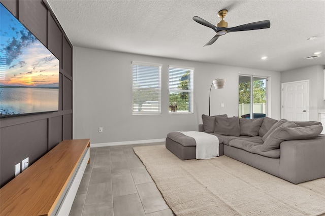 living room with tile patterned floors, a textured ceiling, and ceiling fan