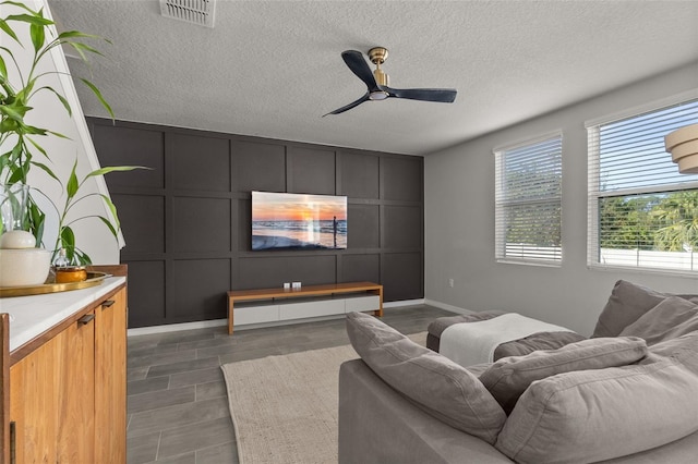 living room with a textured ceiling and ceiling fan