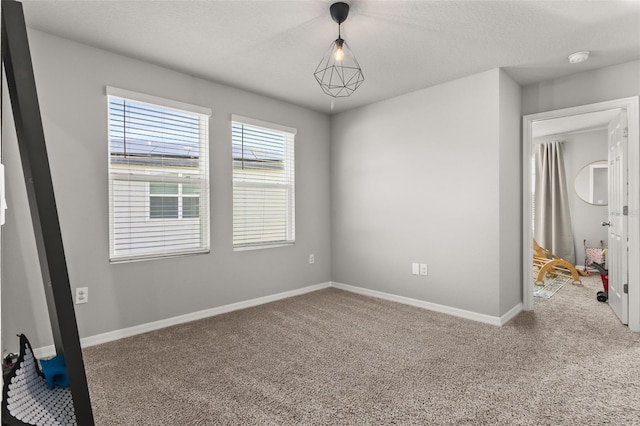 empty room with a textured ceiling and carpet flooring