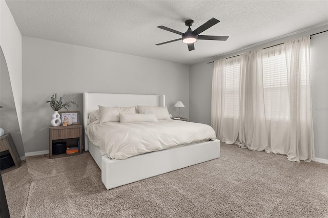 carpeted bedroom featuring a textured ceiling and ceiling fan