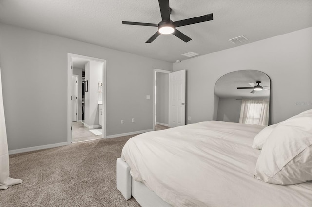 bedroom with carpet, ensuite bathroom, a textured ceiling, and ceiling fan