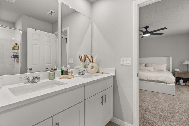 bathroom featuring vanity, ceiling fan, a textured ceiling, and an enclosed shower