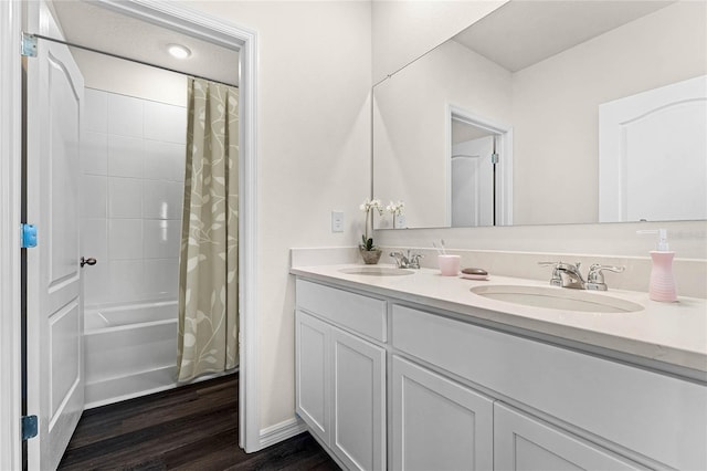 bathroom with hardwood / wood-style floors, shower / bath combo with shower curtain, and vanity