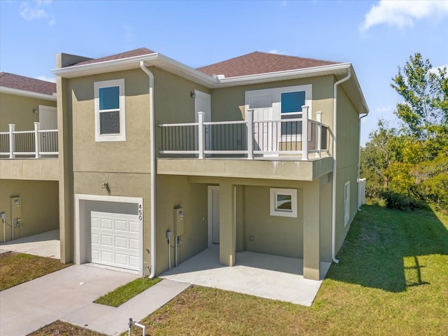 townhome / multi-family property with a front lawn, a garage, and a balcony