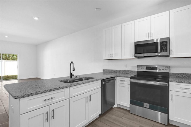 kitchen featuring sink, white cabinetry, kitchen peninsula, and stainless steel appliances