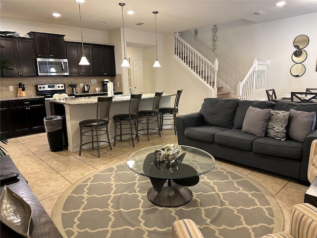 9033 Rhodes St, Kissimmee, FL 34747 - living room with light tile patterned floors, stairs, and recessed lighting