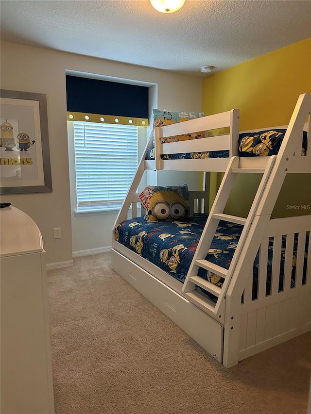 bedroom with a textured ceiling and light colored carpet