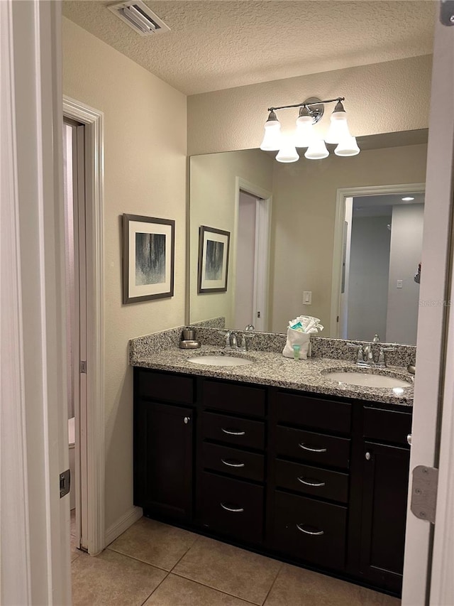 bathroom with vanity, tile patterned floors, and a textured ceiling