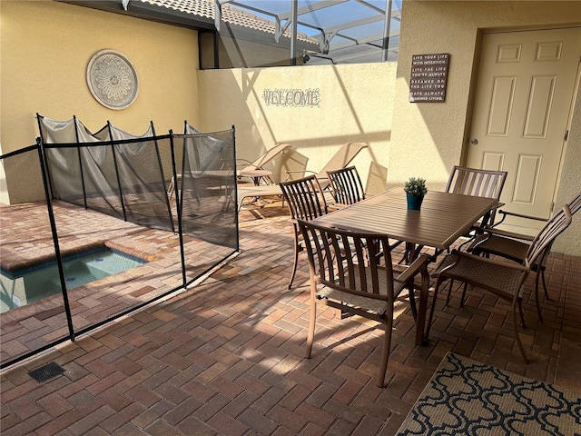 exterior space featuring a hot tub and glass enclosure