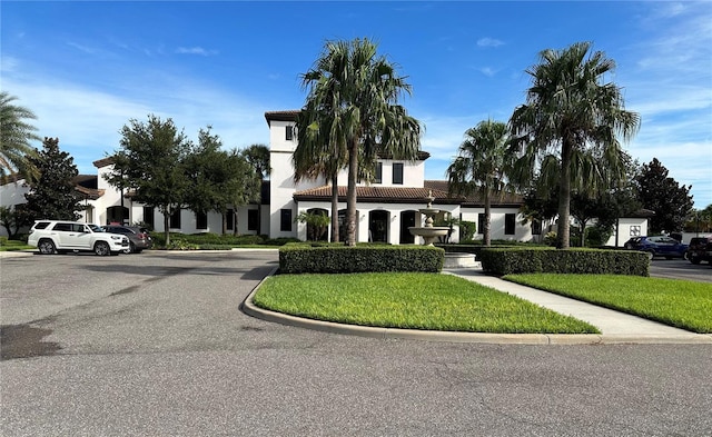 9033 Rhodes St, Kissimmee, FL 34747 - view of front of house featuring a tiled roof, stucco siding, a front yard, and uncovered parking