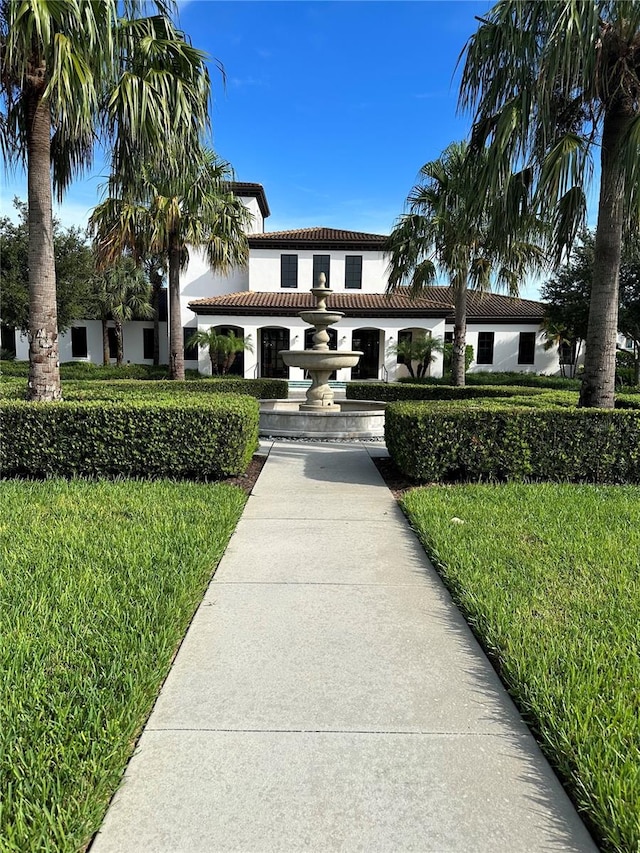 mediterranean / spanish-style house featuring a front lawn