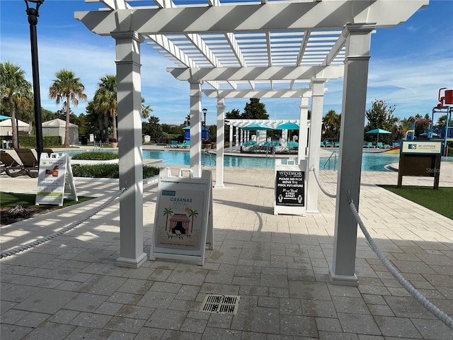 view of patio with a community pool and a pergola