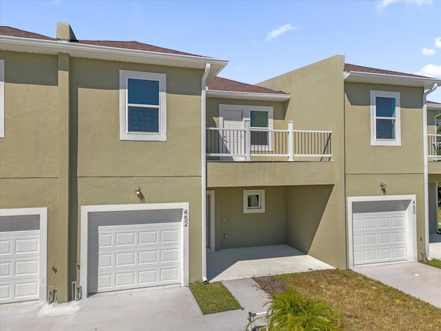 townhome / multi-family property with a balcony and a garage