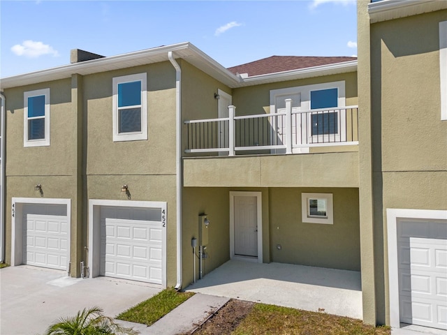 townhome / multi-family property with a balcony and a garage