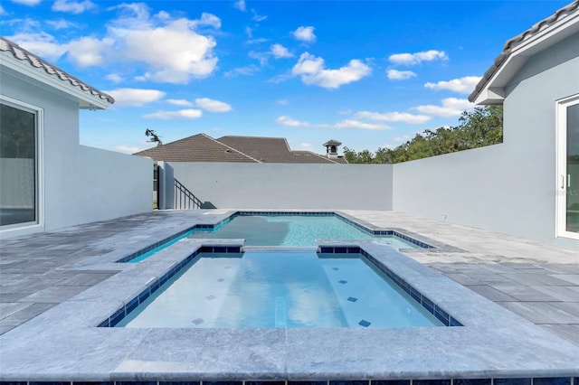 view of pool with a patio and an in ground hot tub