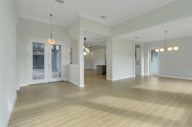 unfurnished room featuring french doors, hardwood / wood-style flooring, and a chandelier