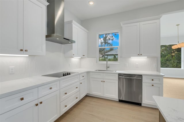 kitchen with wall chimney exhaust hood, white cabinets, stainless steel dishwasher, black electric stovetop, and sink