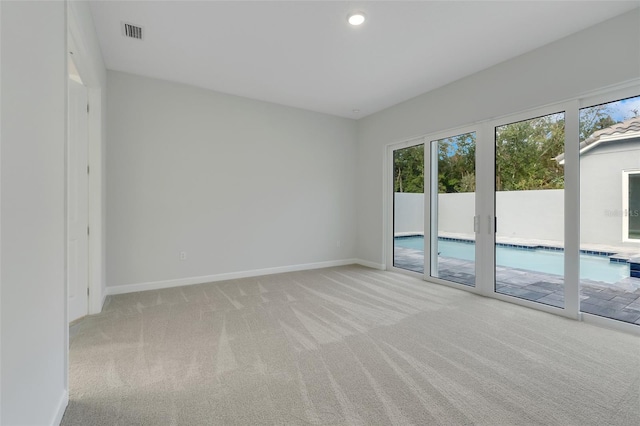 unfurnished room featuring light carpet