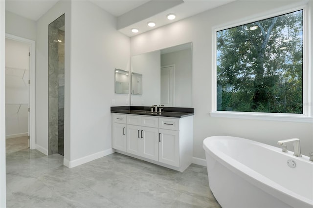 bathroom featuring vanity, a healthy amount of sunlight, and plus walk in shower