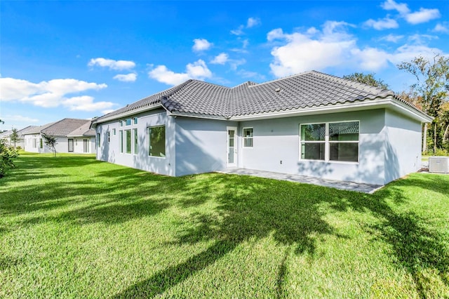 rear view of house with a yard and central AC