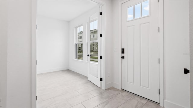 entryway featuring baseboards and a healthy amount of sunlight