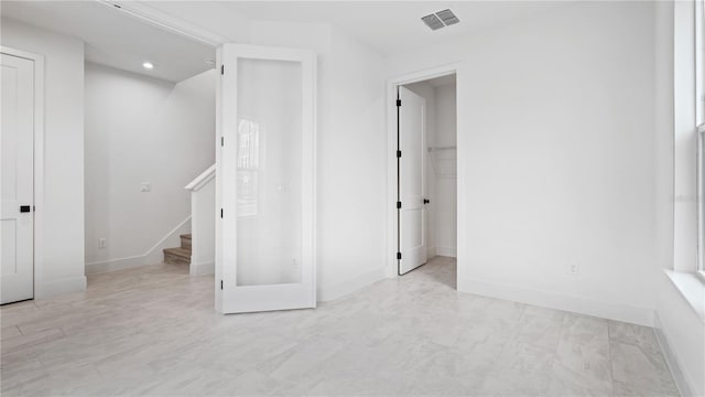 interior space featuring a walk in closet, visible vents, baseboards, and recessed lighting