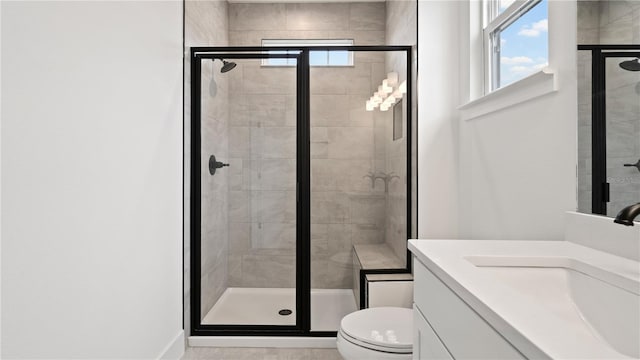 bathroom featuring a stall shower, a wealth of natural light, vanity, and toilet