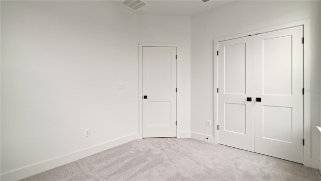 unfurnished bedroom featuring a closet, visible vents, baseboards, and carpet flooring