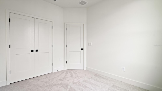 unfurnished bedroom featuring a closet, carpet, visible vents, and baseboards