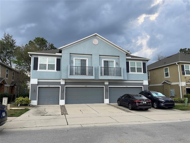 view of front of property featuring a garage, driveway, and stucco siding