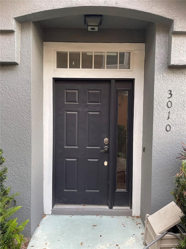 entrance to property featuring stucco siding