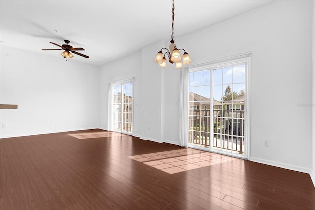 interior space featuring dark wood-style flooring, baseboards, and ceiling fan with notable chandelier