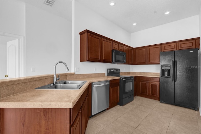 kitchen featuring visible vents, a peninsula, light countertops, black appliances, and a sink