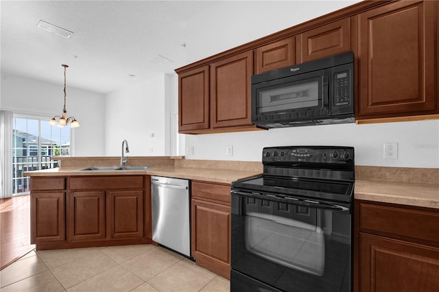 kitchen featuring light countertops, visible vents, an inviting chandelier, a sink, and black appliances