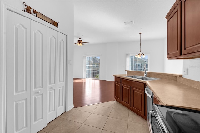 kitchen featuring visible vents, decorative light fixtures, light countertops, a sink, and light tile patterned flooring