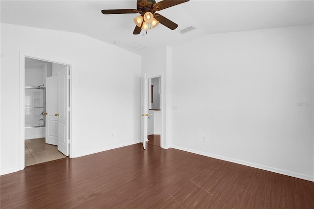 unfurnished bedroom with visible vents, vaulted ceiling, baseboards, and wood finished floors