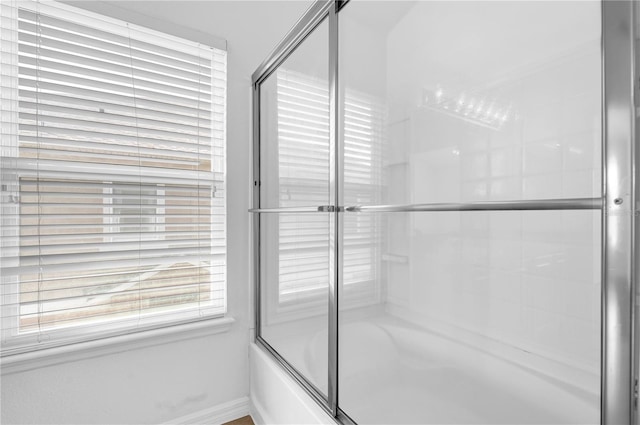 bathroom with shower / bath combination with glass door