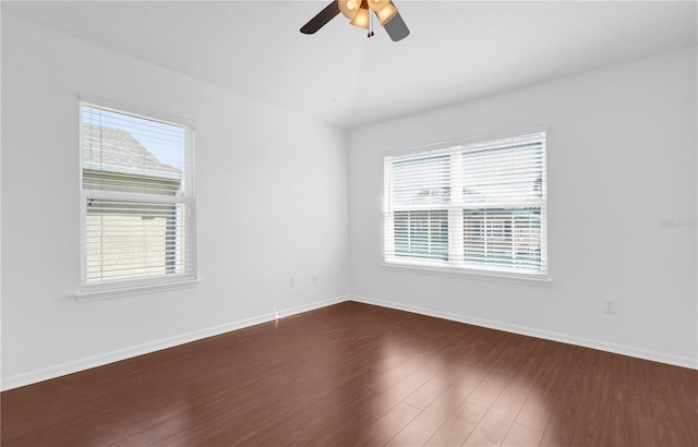 unfurnished room featuring dark wood-style floors, ceiling fan, and baseboards