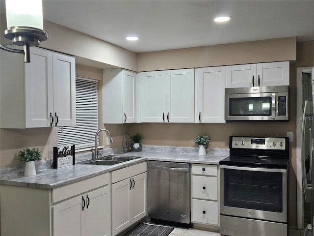 kitchen with sink, white cabinets, and appliances with stainless steel finishes