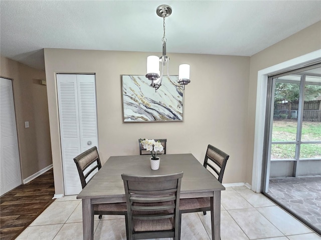 dining space with light hardwood / wood-style floors and an inviting chandelier