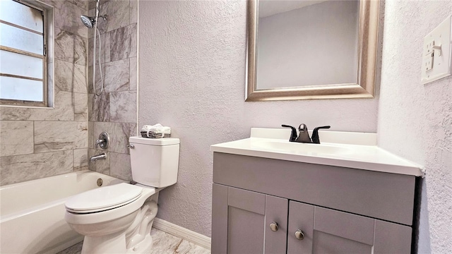 full bathroom featuring tiled shower / bath, vanity, and toilet