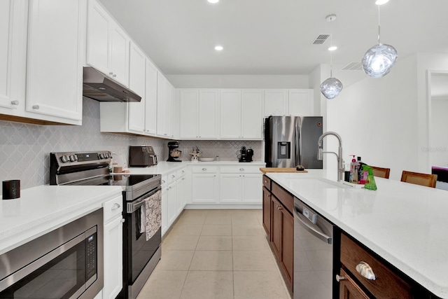 kitchen featuring sink, white cabinetry, stainless steel appliances, pendant lighting, and light tile patterned floors